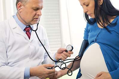 Pregnant woman with preeclampsia having her blood pressure taken.
