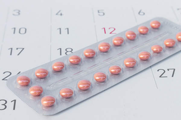 Birth control pills and calendar image.