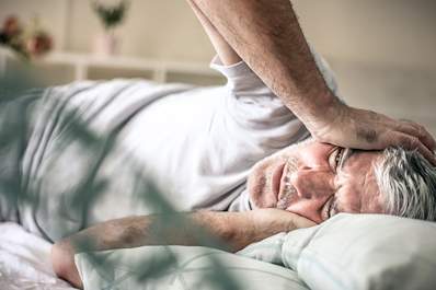 Senior man having trouble falling asleep.
