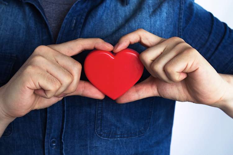 Man holding heart in front of chest.