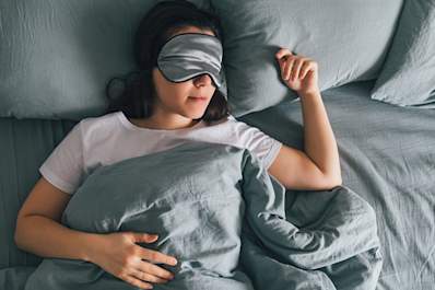 Woman sleeping with sleep mask on her eyes.