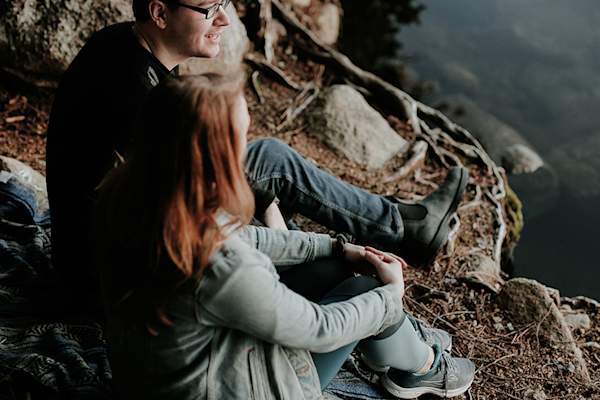 Man and woman talking near a body of water
