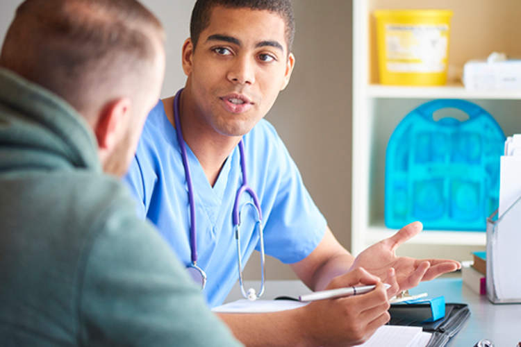 Male doctor talking to young man patient.