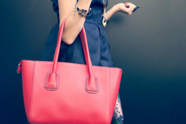 Big red purse being hauled by fashionista.