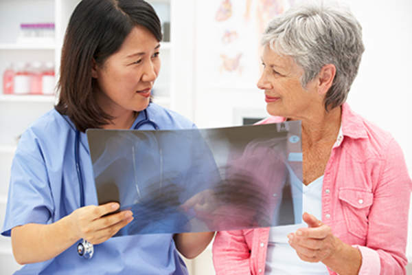 Woman discussing an x-ray with her doctor.