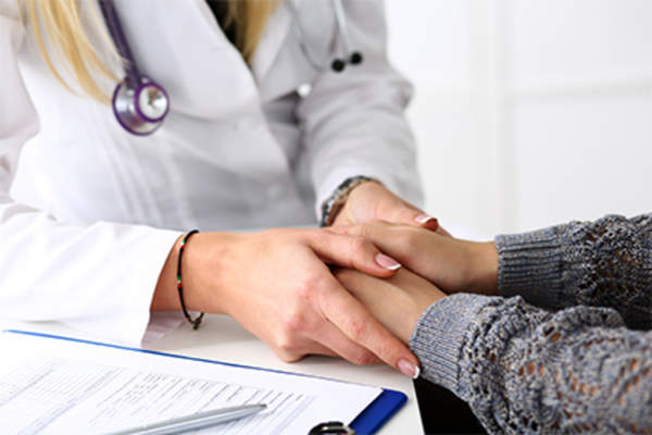 Doctor providing emotional support to her female patient.