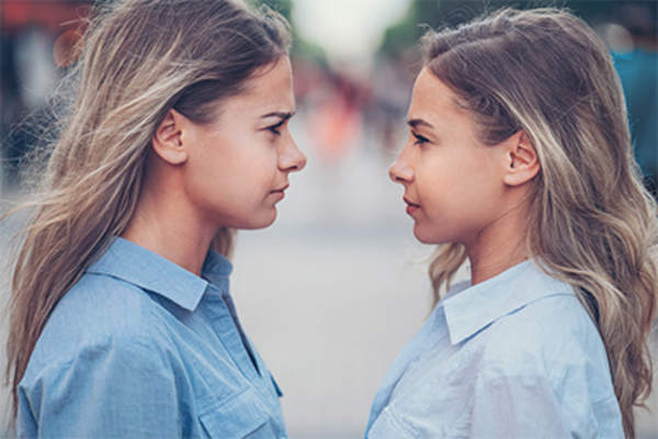 Sisters facing each other, angry.