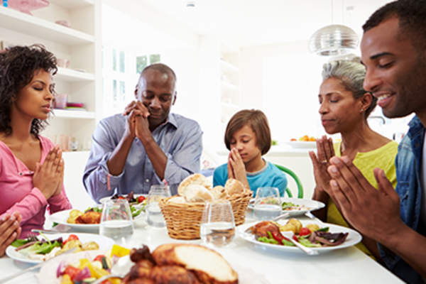 Family saying grace before a meal.