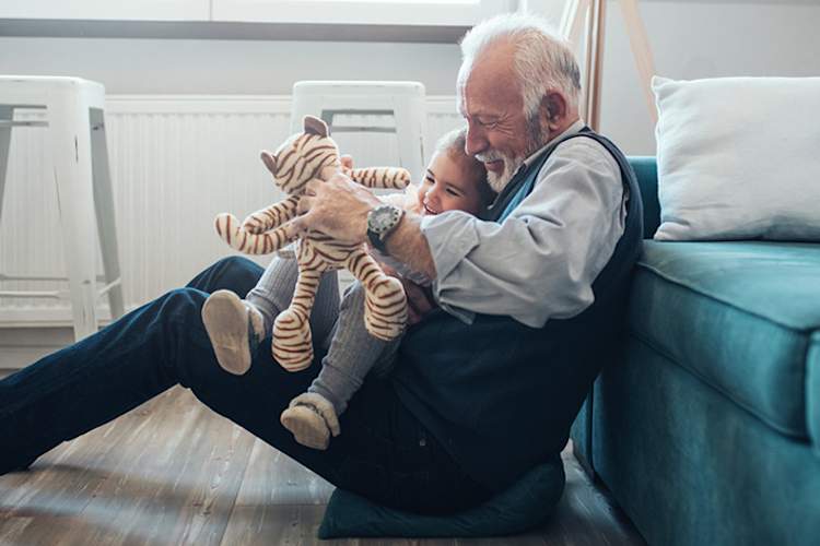 Grandfather playing with toy and young granddaughter.