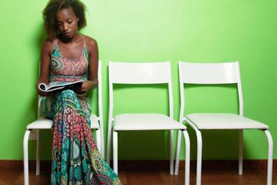Young woman reading a magazine in a waiting room.
