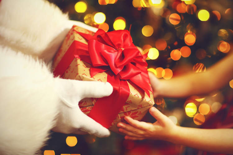 Santa handing a gift to a child.