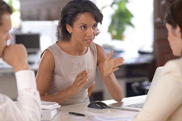 Woman gesturing while explaining something in a meeting.