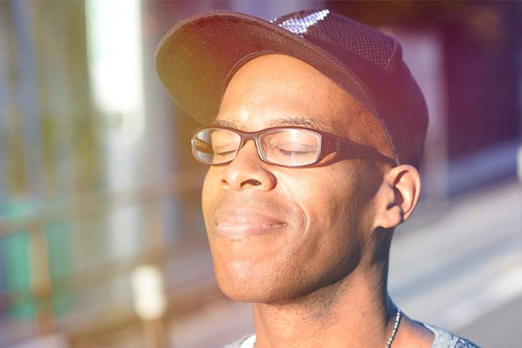 Hopeful man enjoying the sunshine on his face.