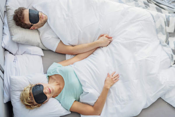 Couple sleeping well in sleep masks.