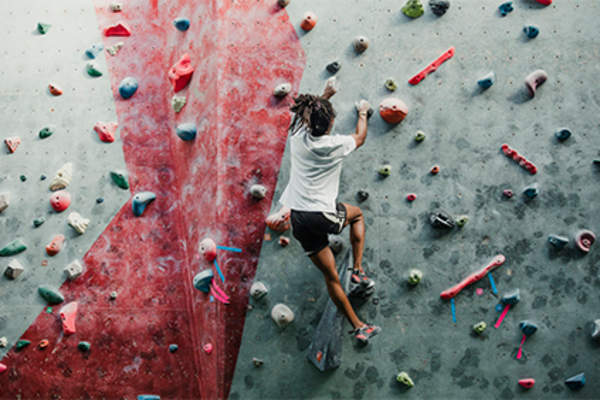 Woman climbing rock wall.