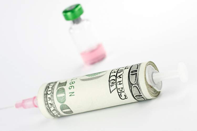 A roll of 100 dollar bills around an insulin syringe.