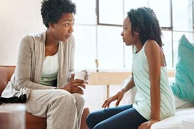 Mother talking to teen daughter in her room.