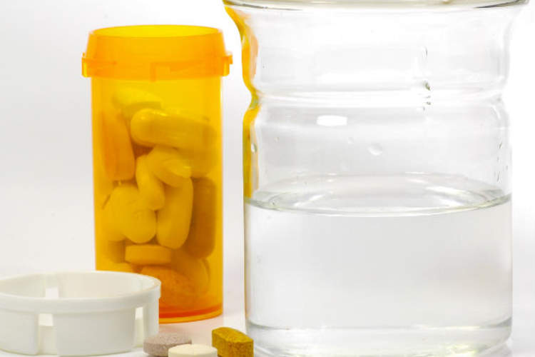 generic bottle of pills with glass of water