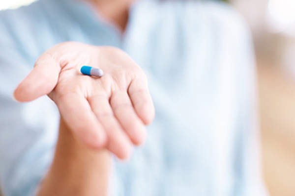 Woman holding pill