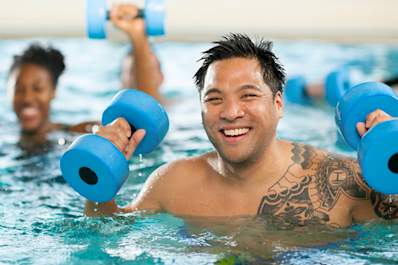 Smiling man in water aerobics class.