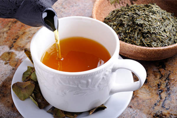 Pouring cup of green tea.
