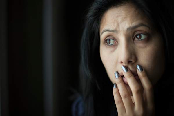 woman covering mouth looking upset