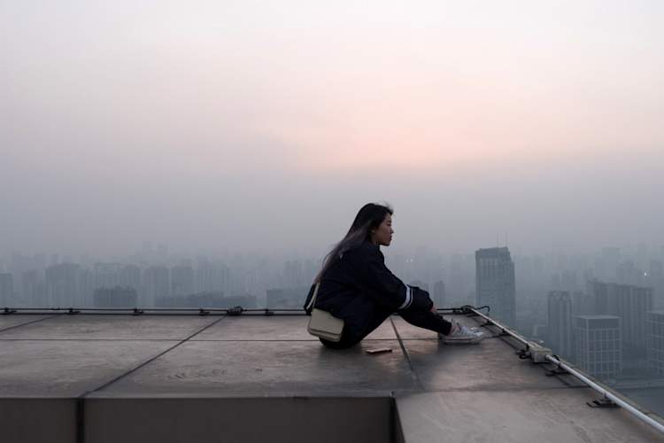 pensive woman sitting on roof