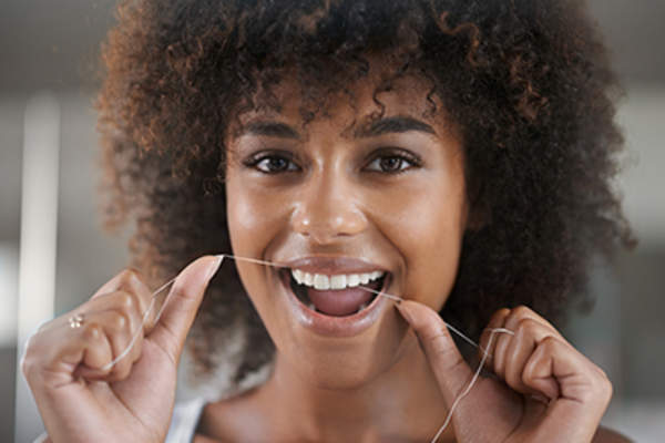 Woman flossing her teeth.