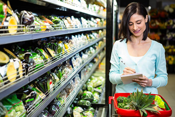 Woman checking off a grocery list.