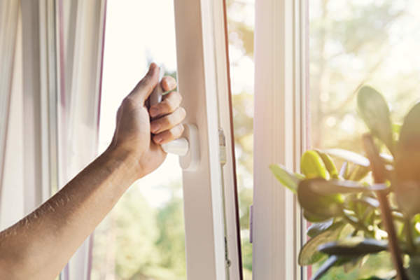 Hands closing a window.