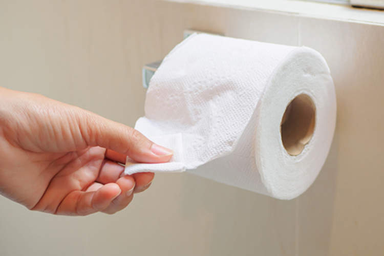 Woman getting toilet tissue.