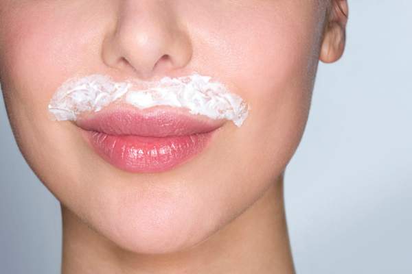 woman with hair removing cream on upper lip