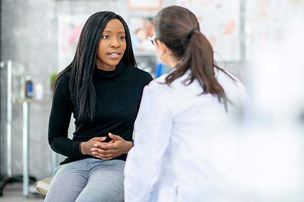 Woman discussing options for IBD treatment with her doctor.