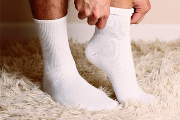 Man putting on white socks.