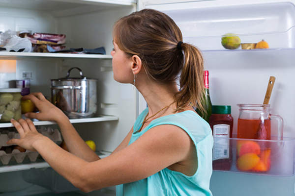woman cleaning out refridgerator image