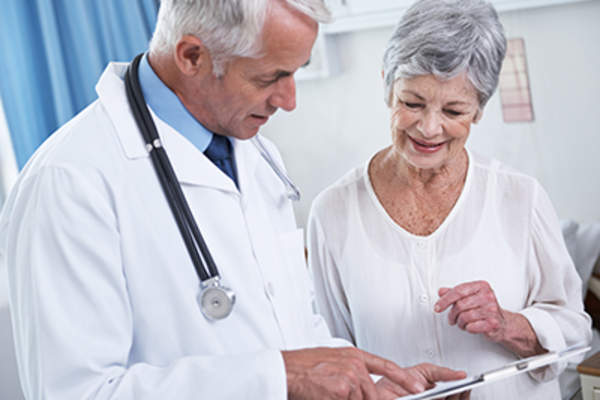 Woman smiling while talking to a doctor.