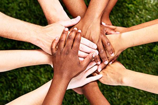 Hands stacked in unity and support.