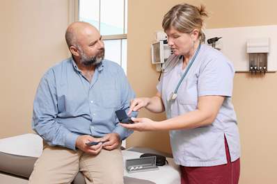 Nurse explaining diabetes equipment.