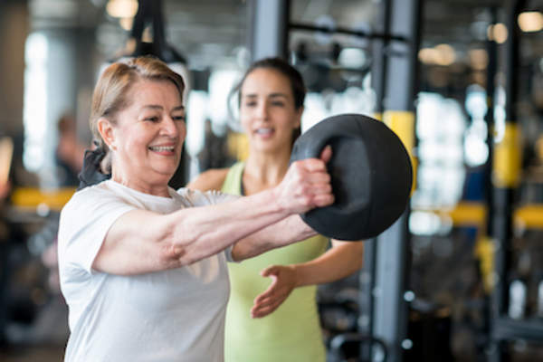 Strength training at gym with trainer.