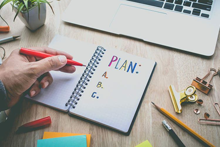 Writing a plan for resolutions in a notebook.
