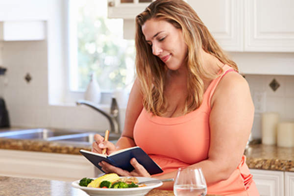 Woman writing in a food diary.