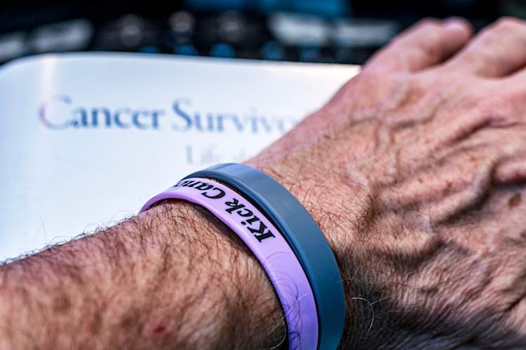 Cancer patient reaching for survivorship pamphlet.