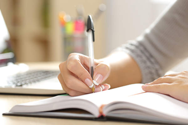Woman writing in a notebook.