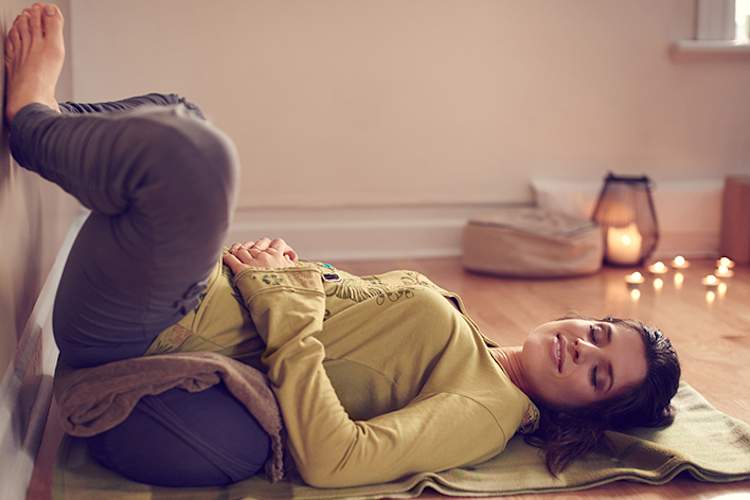 Woman practicing restorative yoga to prevent a psoriasis flare.