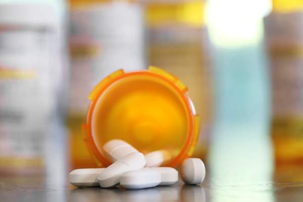 Pills pour out of a prescription medication bottle