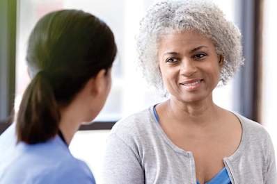 Smiling woman with diabetes talking to her doctor.