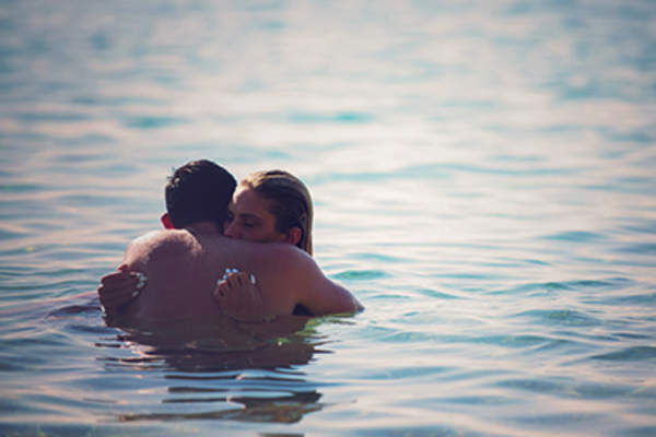 Young couple hugging in a lake.