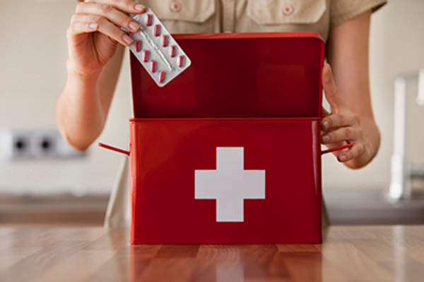 Putting pills in a first aid kit.
