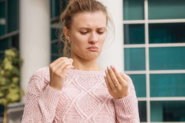 Woman looking at her fingernails.