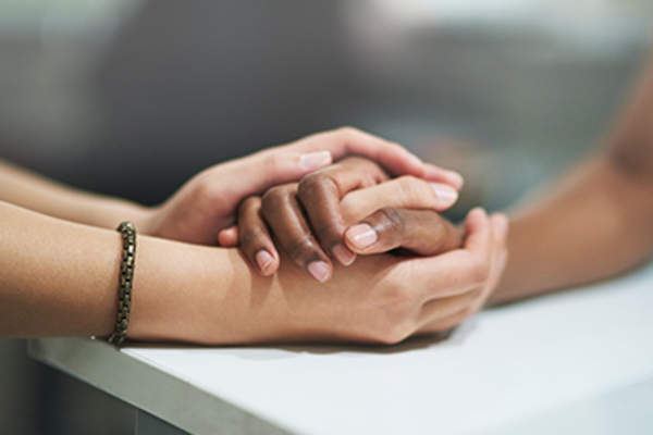 Comforting a friend by holding their hand